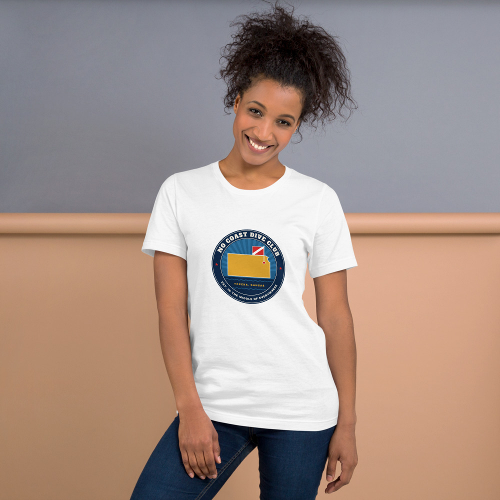Person wearing a white No Coast Dive Club t-shirt with the Kansas dive flag badge